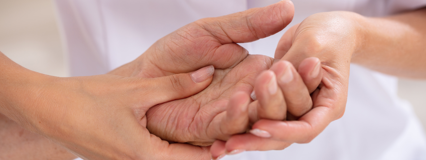 A nurse massages a patients hand