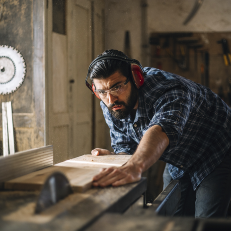 Carpenter cutting wooden plank