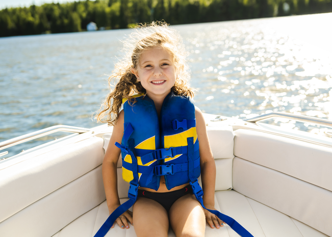 Young girl wearing life jacket sitting on a boat.