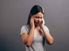 Woman rubs head in pain