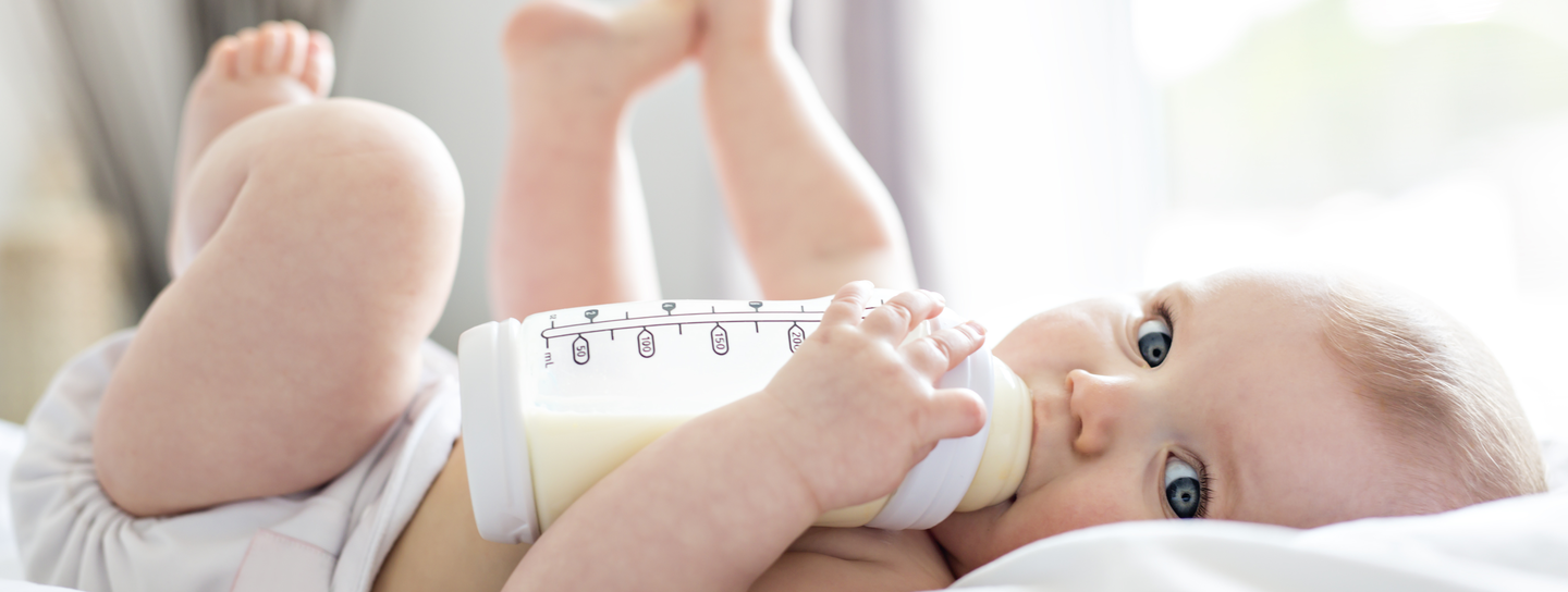 Baby drinks milk while lying on their side.