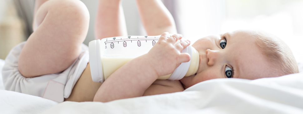 Baby drinks milk while lying on their side.