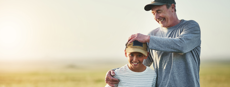 father and son playing with a football on a field