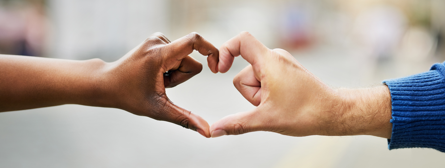 Two hands making the heart sign.
