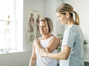 Provider stretches woman's shoulder.