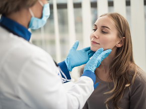 A doctor looks into the ear of a patient