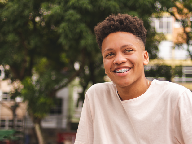 Teenage boy sitting outside looking into distance
