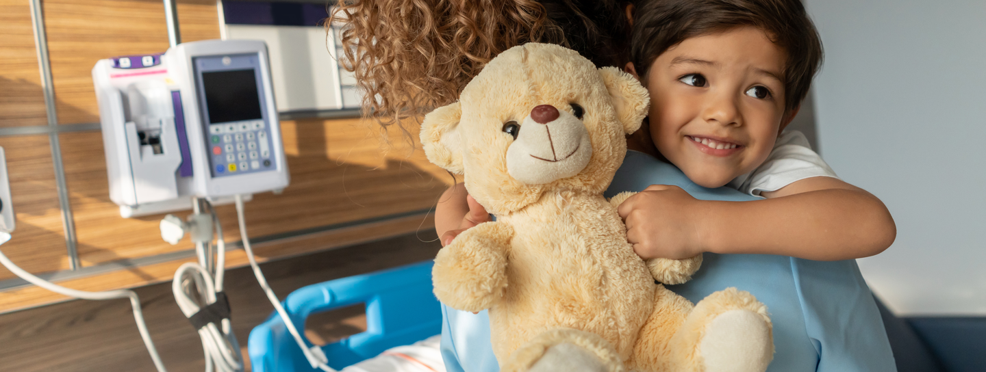 young boy hugging teddy bear