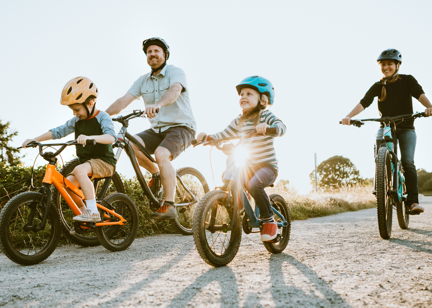 Family riding bikes together in the foothills. 