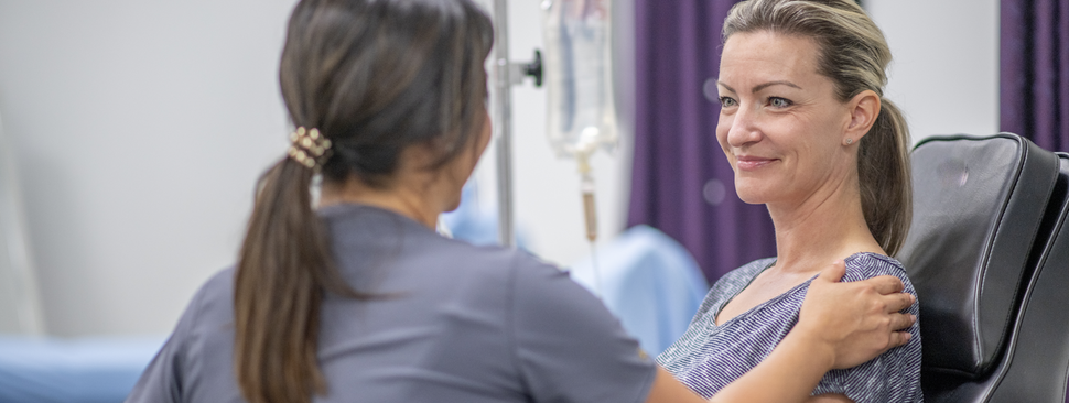 woman receiving infusion with caring nurse