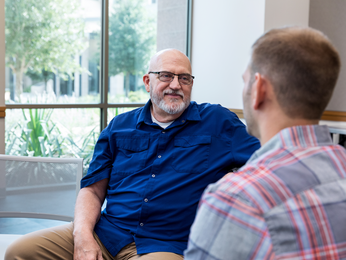Two men sitting and talking together