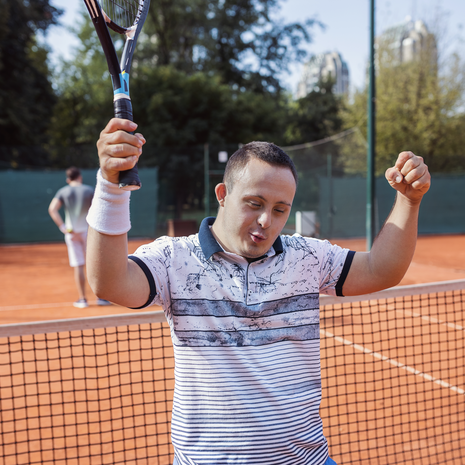 Young man with Down syndrome playing tennis
