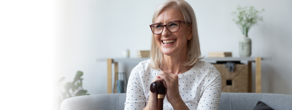 Happy woman with a cane in her living room