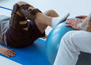 patient with sports related leg injury receives physical therapy