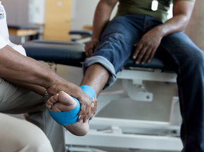 Doctor holding injured foot of patient