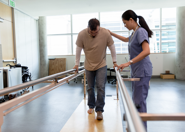 Man walks with support beams as Provider holds their shoulder.