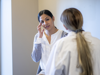 Woman describing headache to physician