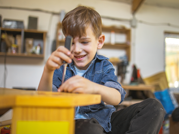 Child tinkering with wood and tools