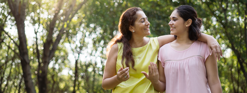 Adult mother and daughter walk together in the woods