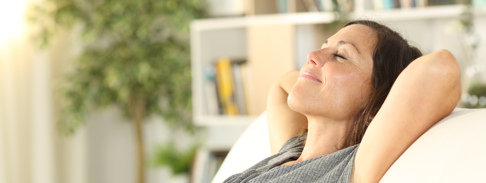 Woman relaxing on the couch taking a deep breath