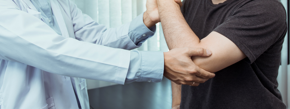 Doctor inspecting mans elbow