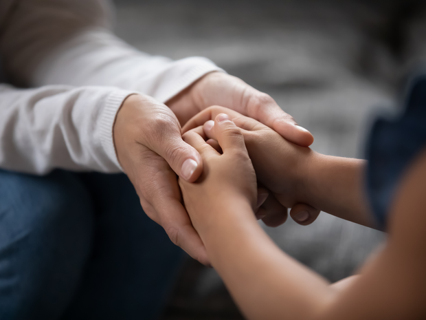 Child holds hands with provider.