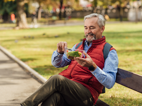 Senior man enjoying outdoors and eating salad