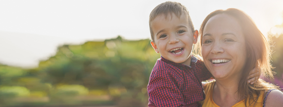 Provider smiles while tending to patient in hospital bed.