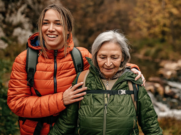 Young woman walking with an elderly woman along a trail.