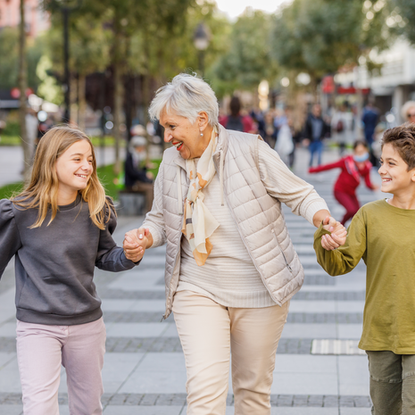 An older woman is enjoying time with her grandchildren in the city