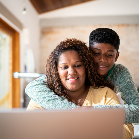 A mother and her son accessing health services through her laptop.