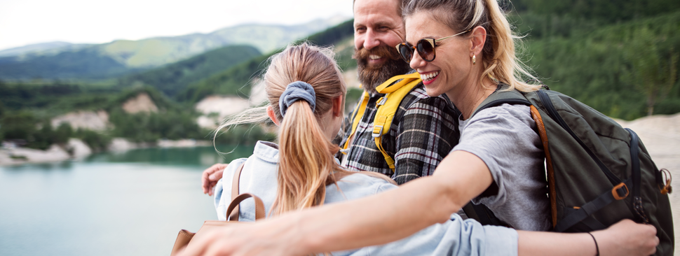 A family stops for a group hug while on a hike