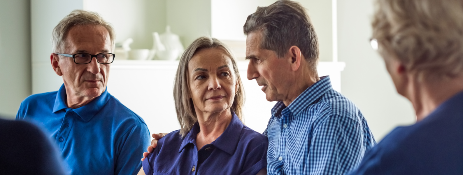 An older person speaking to a group.