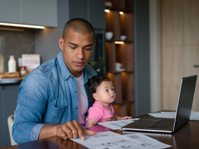 Father trying to work at home while taking care of his baby