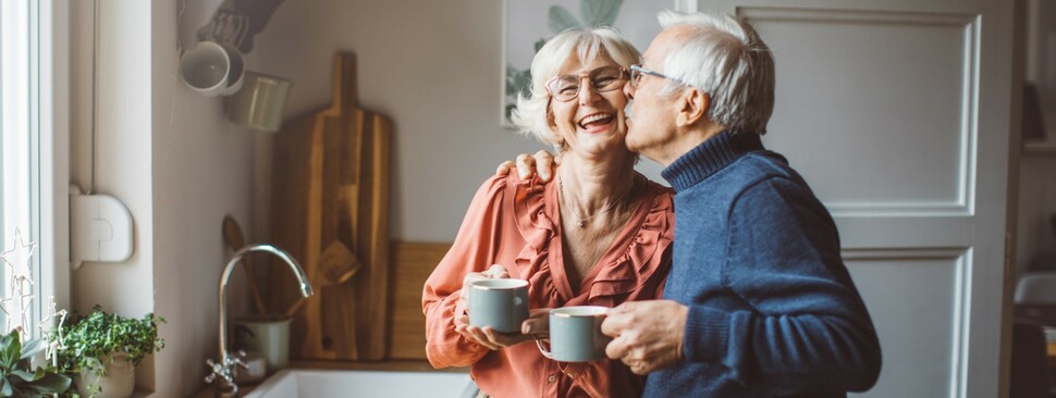 An older couple together in kitchen