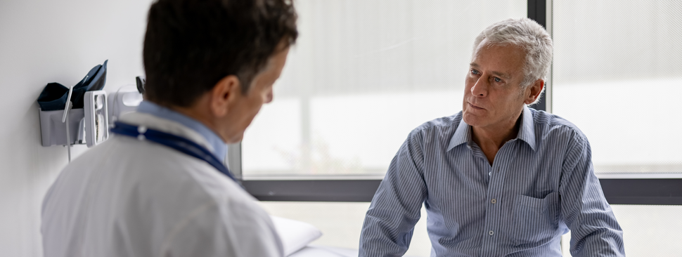 Doctor with older male patient in clinic office