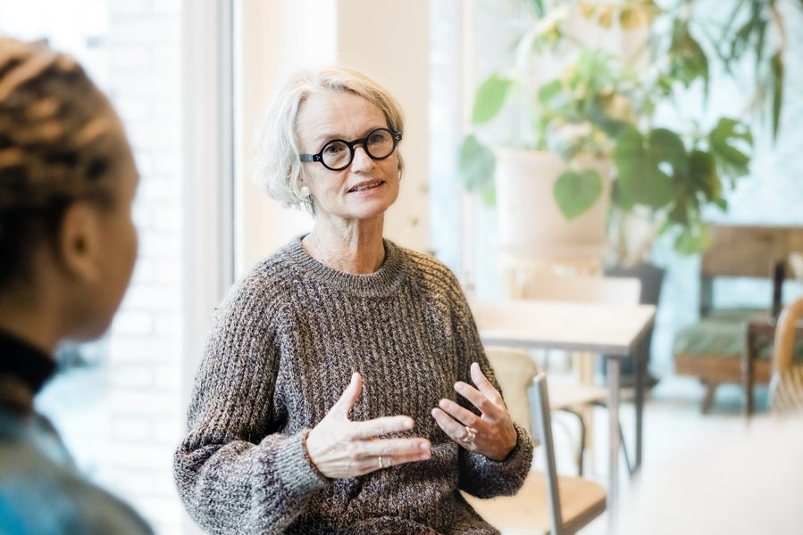 Woman with round glasses speaking.