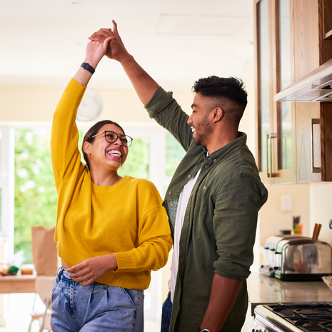 Young couple dancing together in their kitchen