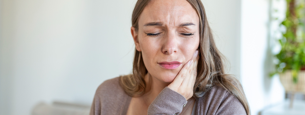 woman touching her cheek in discomfort