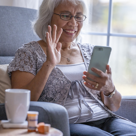 woman waving at laptop