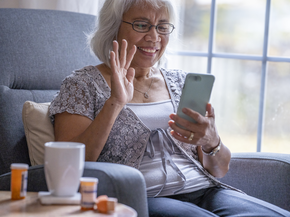 Woman waves hello on the phone