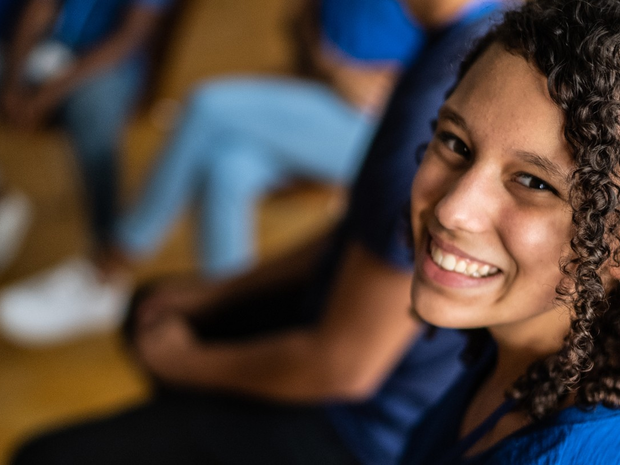 Young woman smiles while volunteering at St. Luke's