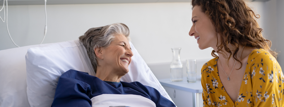 Senior woman in the hospital being visited by her daughter