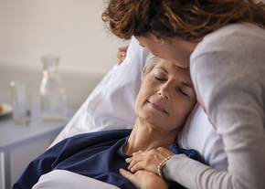 Woman kissing her mother at hospital 