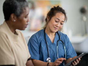 Provider speaks with another health professional while pointing at screen