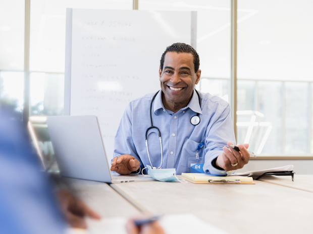 Male provider smiles at a table.