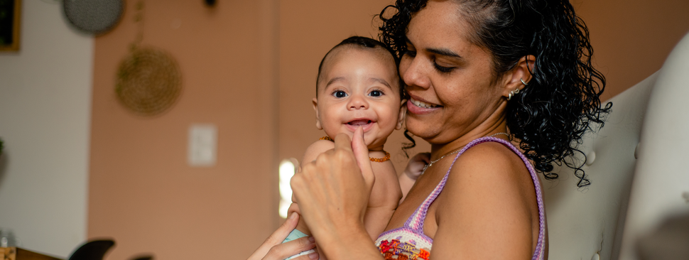Baby smiling on mother's lap