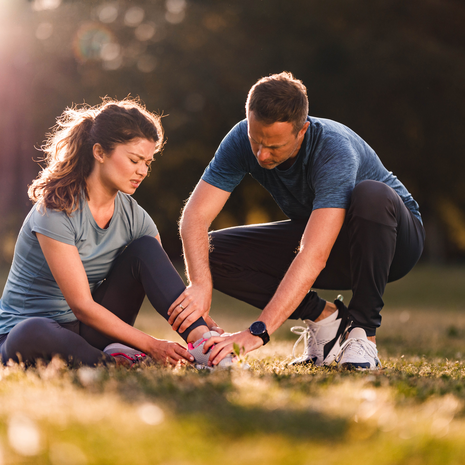 Athletic trainer helping injured athlete