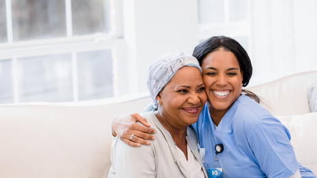 Older woman looks strong getting a caregiver hug.