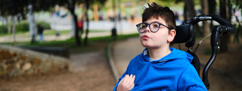boy in wheelchair enjoying the day outdoors in the park